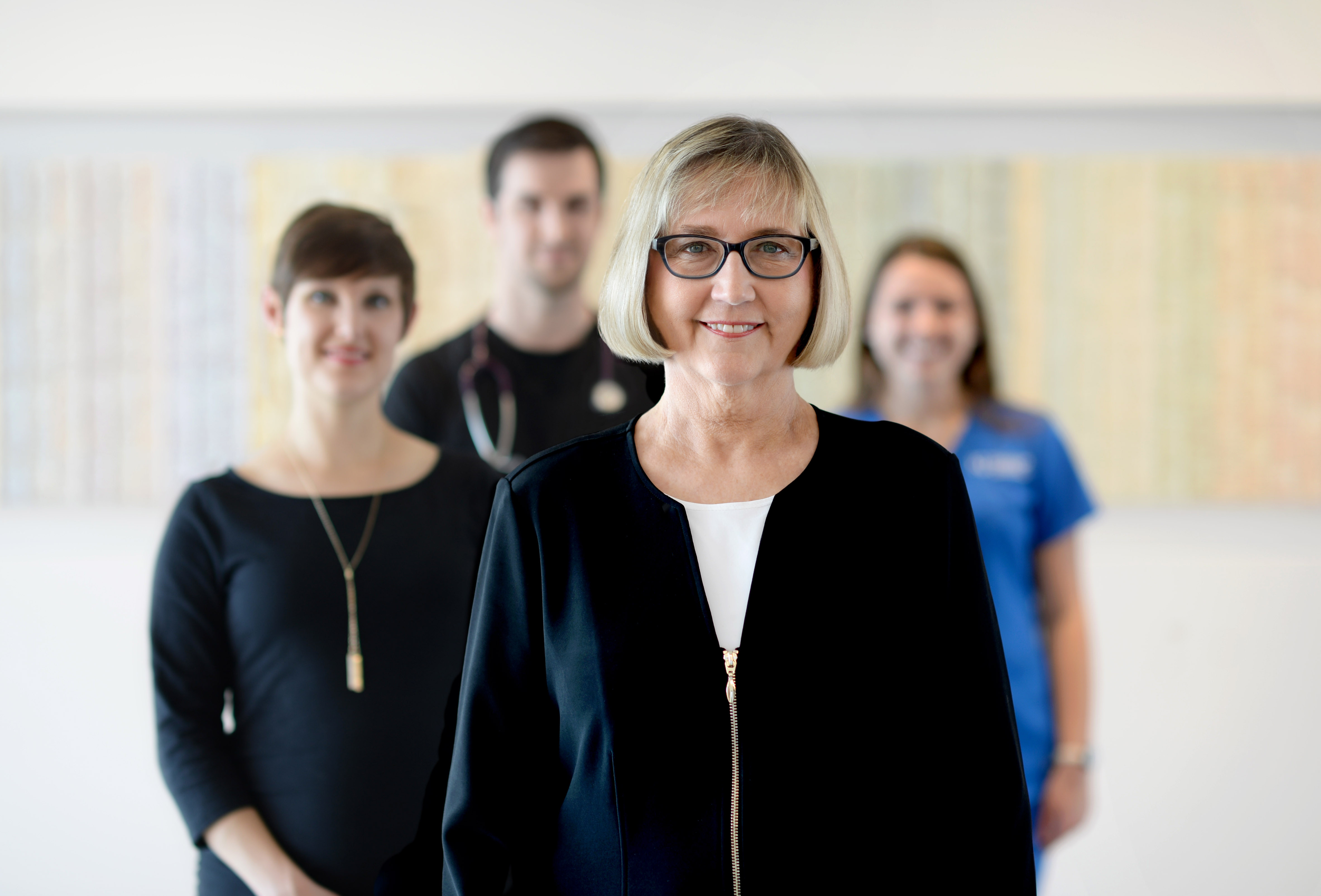 Portrait of Nelda Godfrey standing in front of students blurred in the background