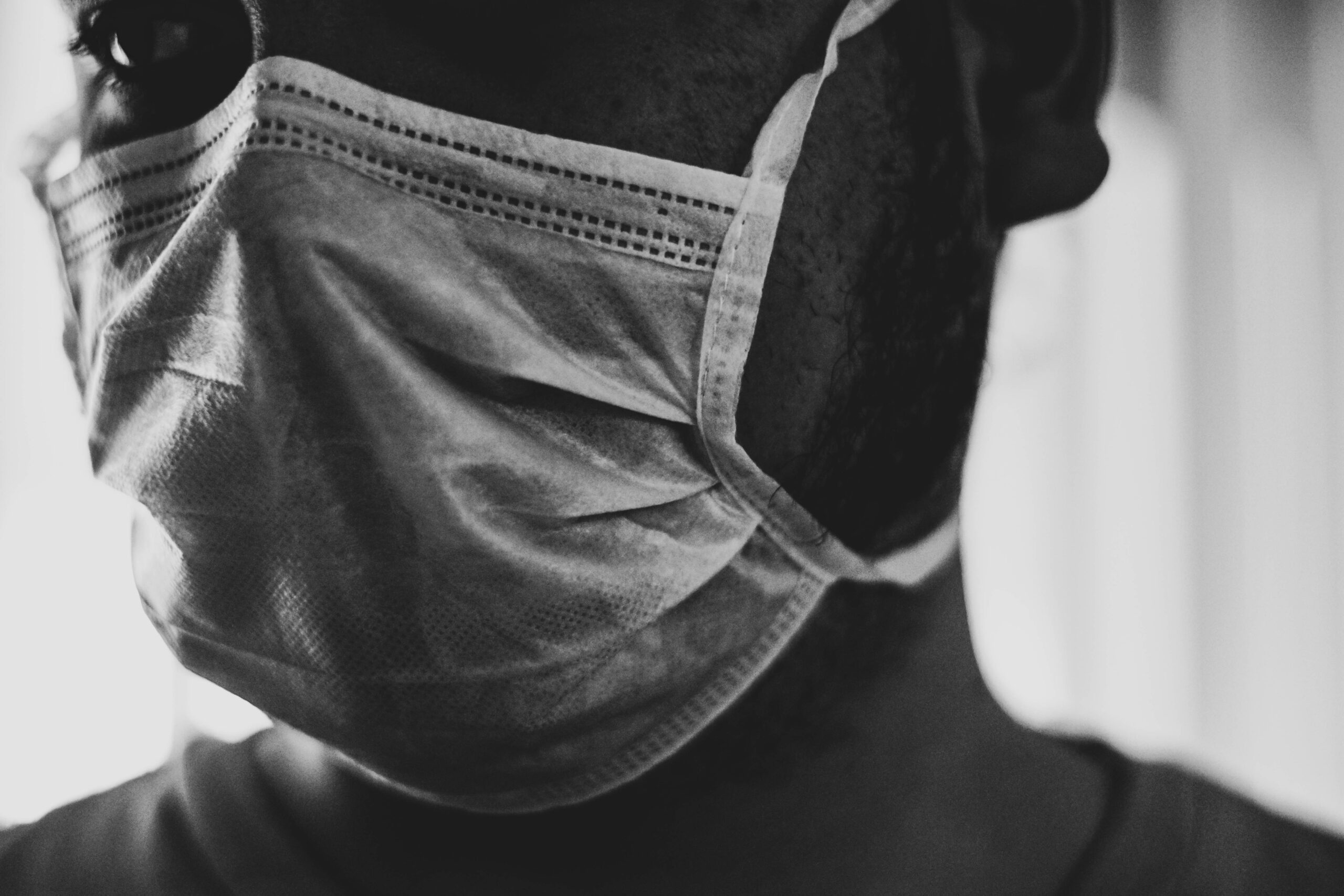 A black and white photo of someone wearing a mask